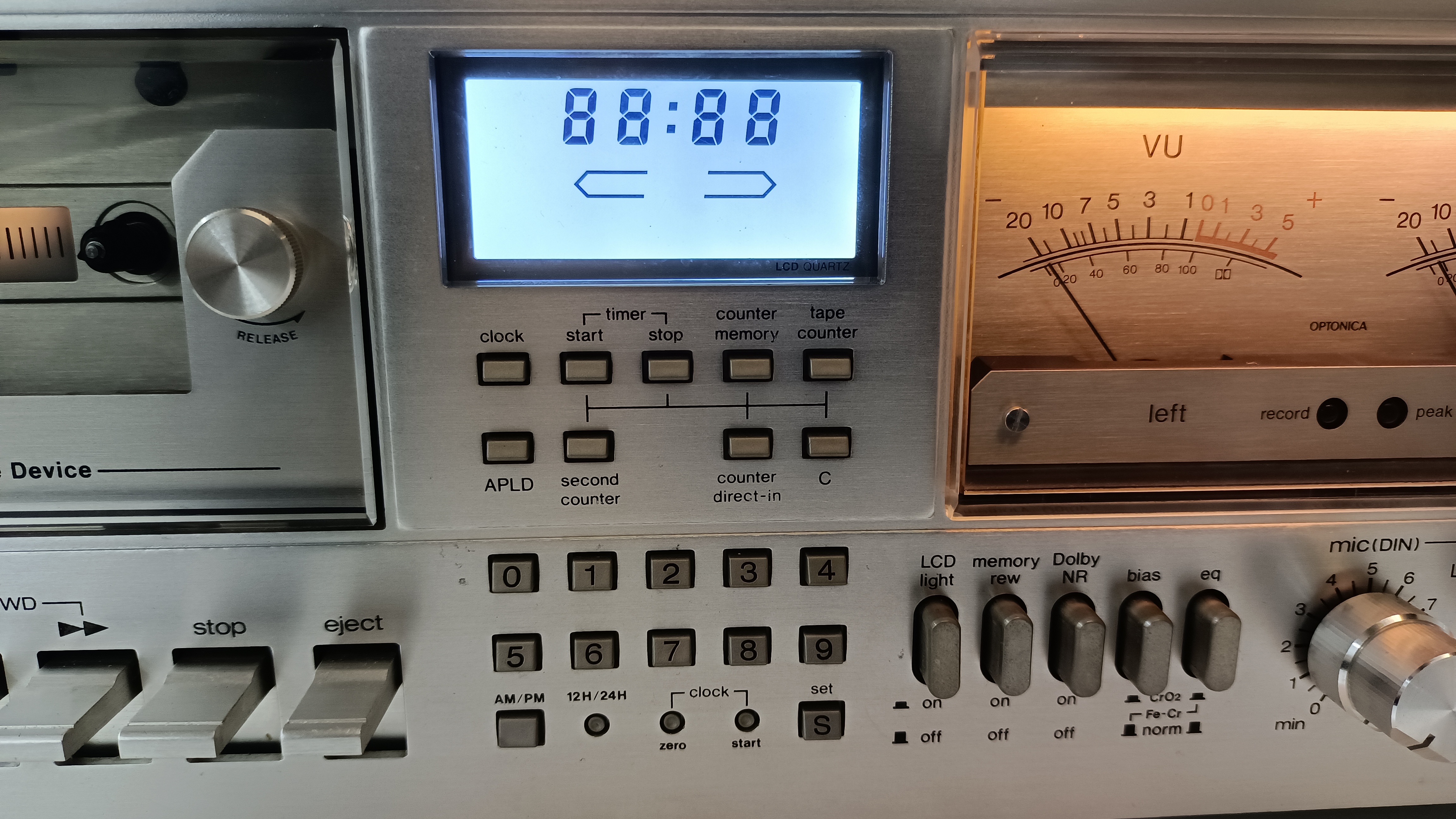 Close-up of the RT-3150 display section: blue LCD showing all segments, VU meter, level sliders and microphone input
