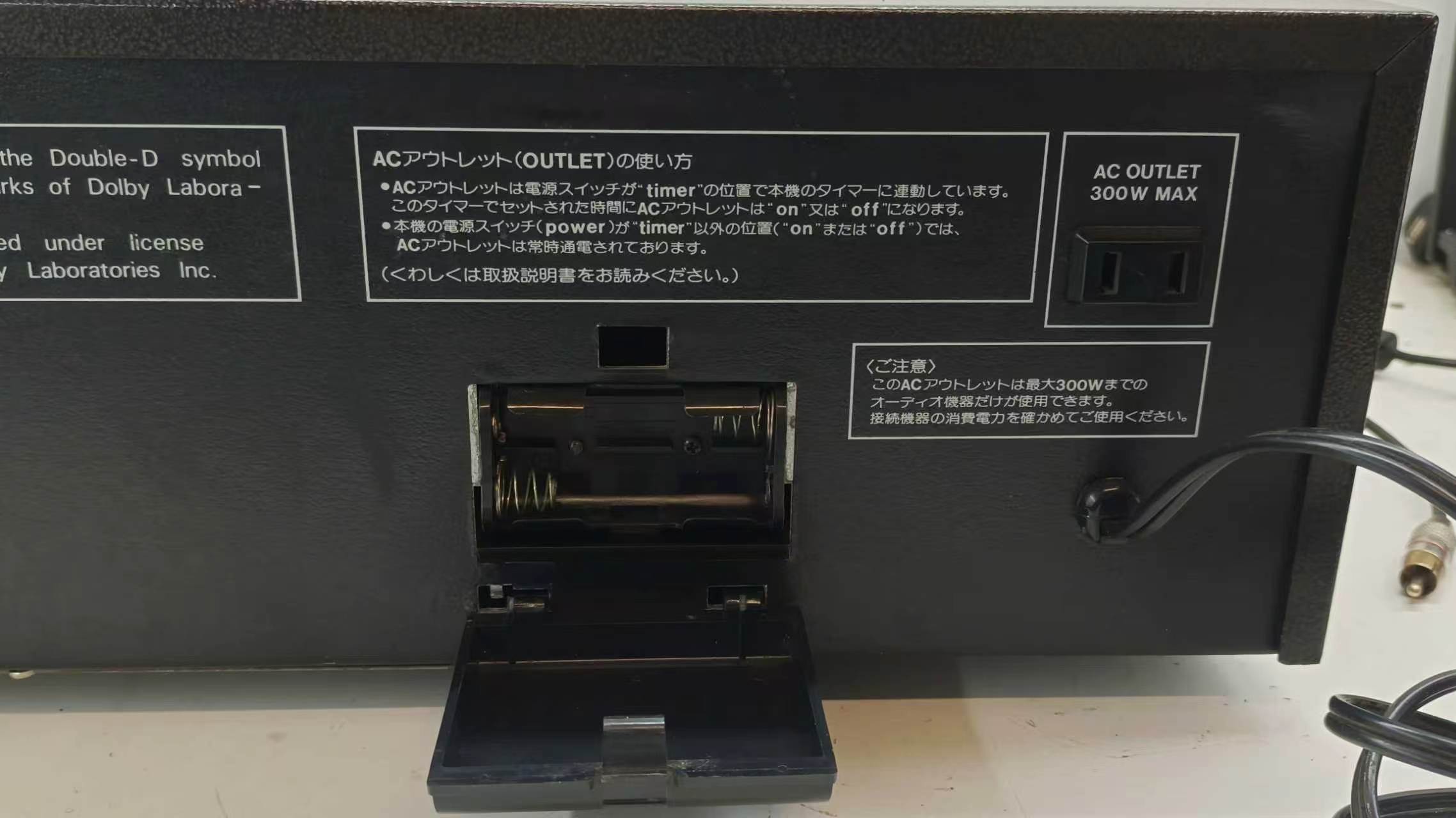 Rear panel close-up: Dolby trademark note, AC outlet (300W max) and mains cord